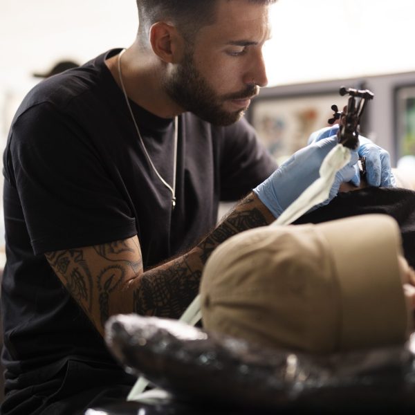 medium-shot-tattoo-artist-doing-his-job-min